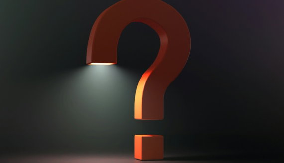 A large orange question mark illuminated by a bright light from below